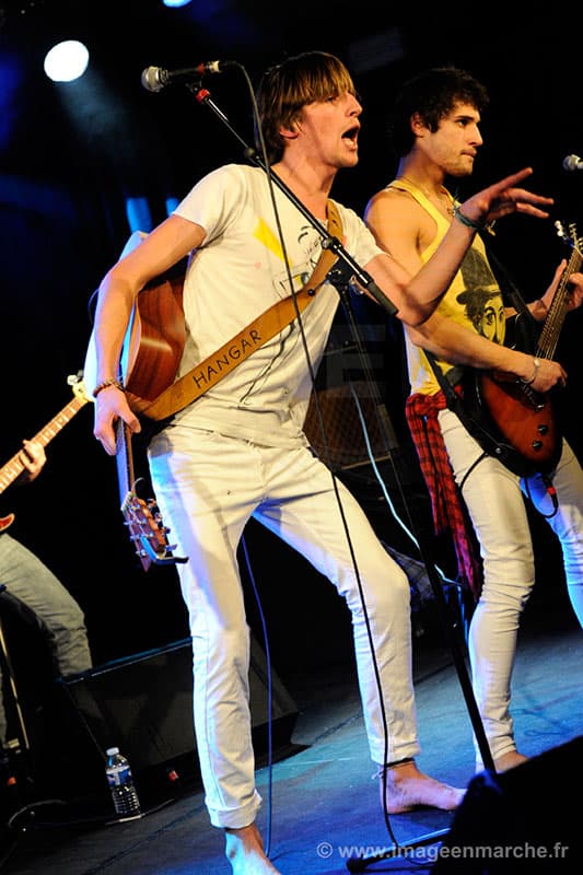 Chanteur et guitariste de Hangar en pleine énergie, sangle marquée Hangar, concert privé