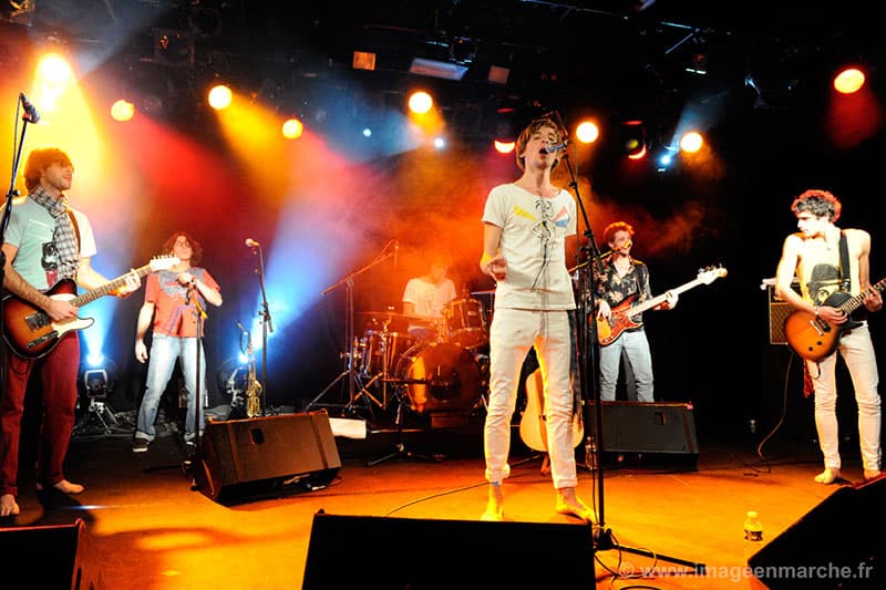 Concert privé du groupe Hangar sur scène, musiciens et chanteur pieds nus au micro